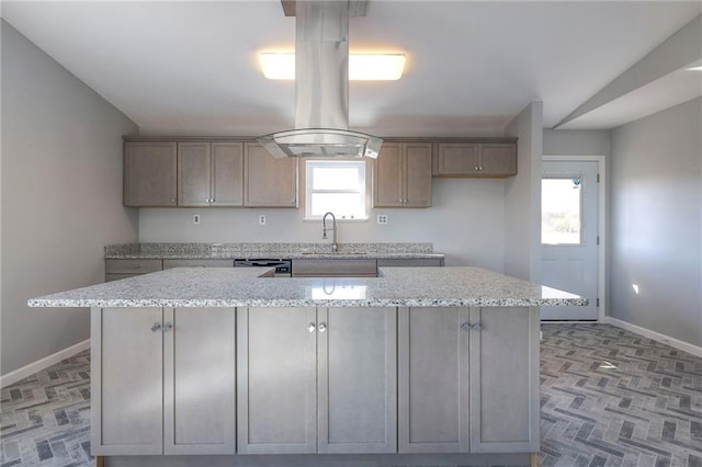 kitchen featuring lofted ceiling, light stone countertops, and a kitchen island