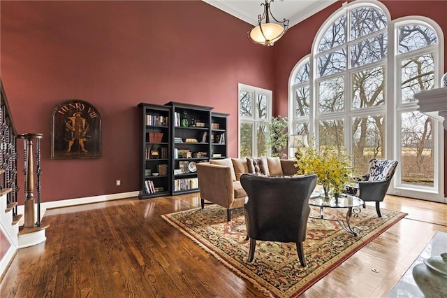 living area featuring stairs, a high ceiling, plenty of natural light, and wood finished floors