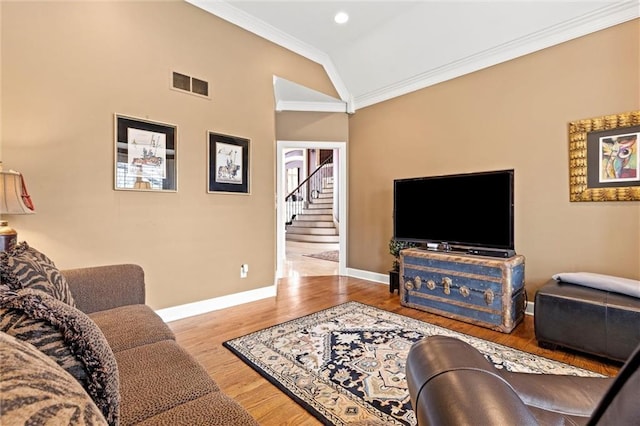 living room featuring baseboards, visible vents, ornamental molding, wood finished floors, and vaulted ceiling