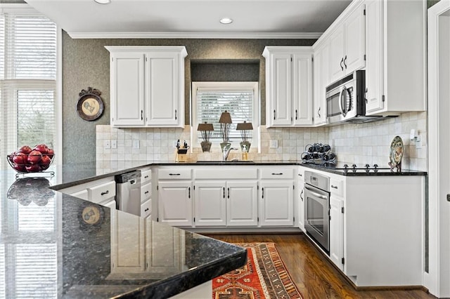 kitchen featuring crown molding, stainless steel appliances, white cabinetry, a sink, and wallpapered walls