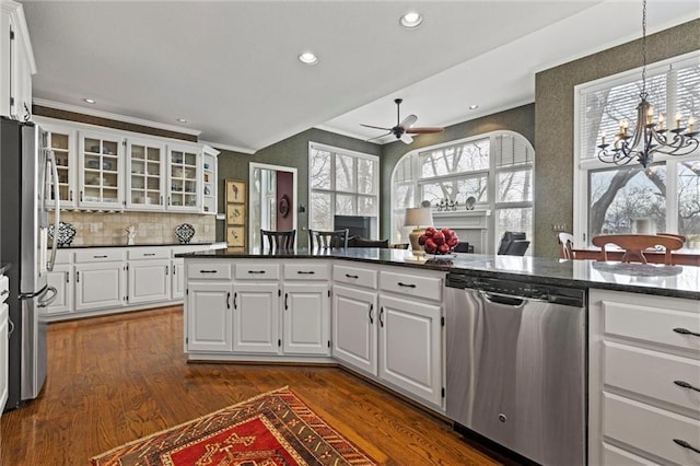 kitchen with appliances with stainless steel finishes, white cabinets, glass insert cabinets, and dark wood-style floors