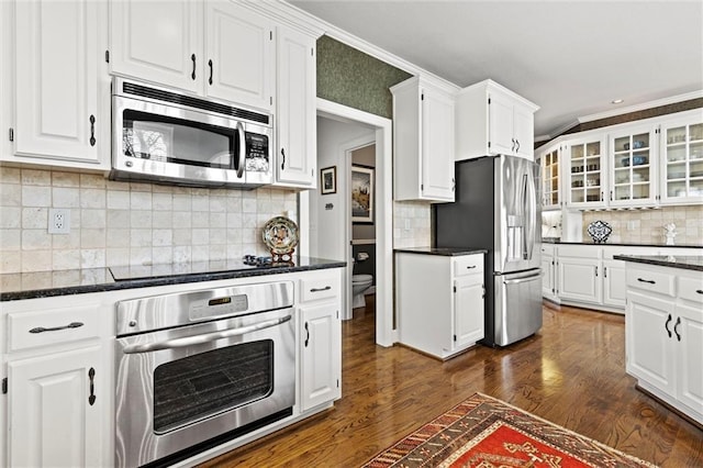 kitchen featuring stainless steel appliances, glass insert cabinets, and white cabinetry