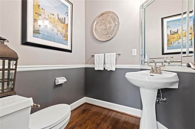 bathroom featuring toilet, baseboards, and wood finished floors