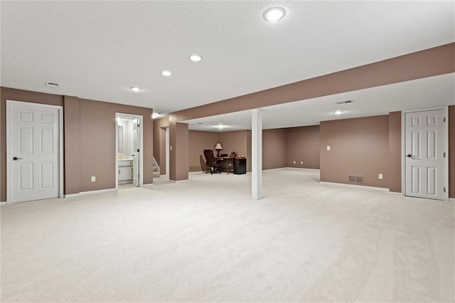 finished below grade area featuring recessed lighting, visible vents, and light colored carpet