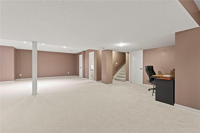 office space featuring light carpet, a textured ceiling, and baseboards