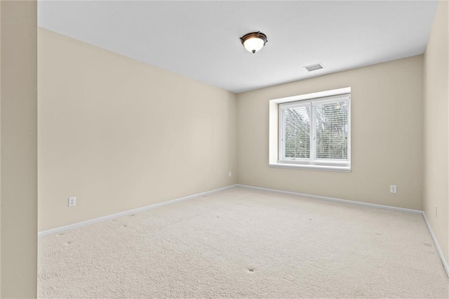 spare room with baseboards, visible vents, and light colored carpet