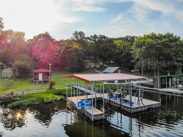 dock area with a water view and a lawn