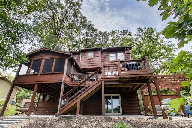 back of property with a sunroom and a deck