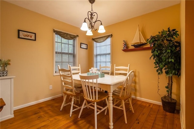 dining area featuring wood-type flooring and a chandelier