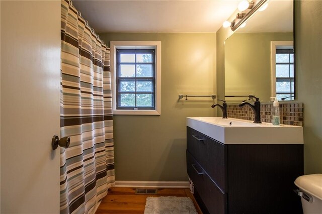 bathroom with wood-type flooring, toilet, and vanity