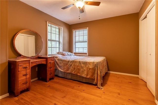 bedroom featuring ceiling fan, a closet, and light wood-type flooring