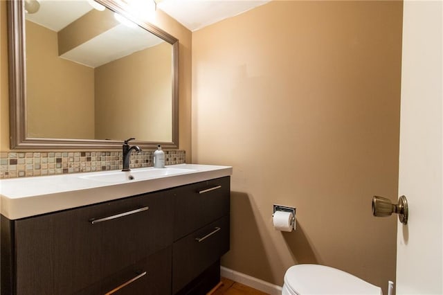 bathroom with vanity, tasteful backsplash, and toilet