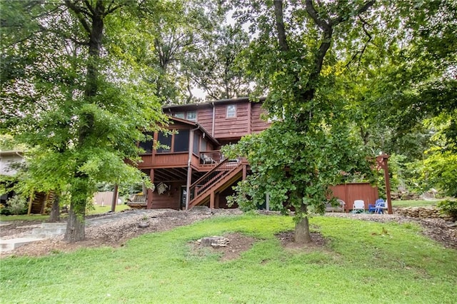 back of property with a yard, a deck, and a sunroom