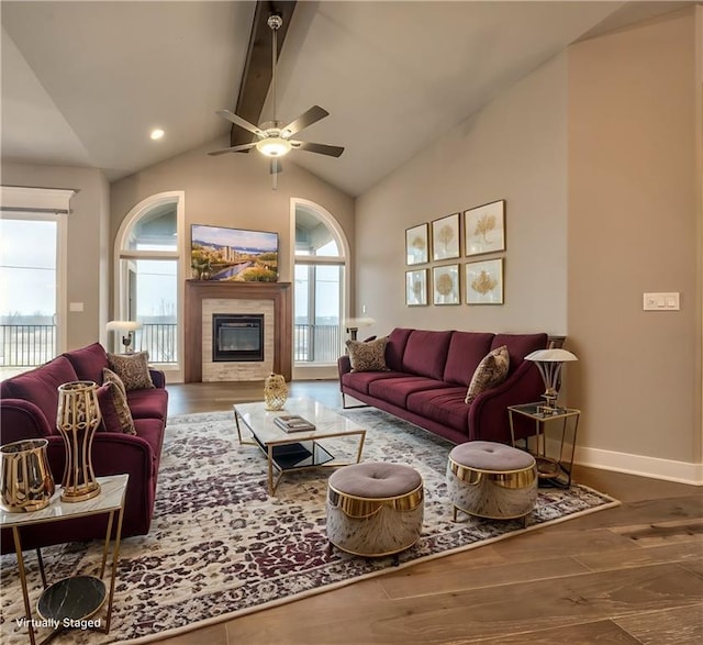 living room featuring hardwood / wood-style floors, vaulted ceiling with beams, and ceiling fan