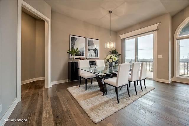 dining space featuring a notable chandelier and dark hardwood / wood-style flooring