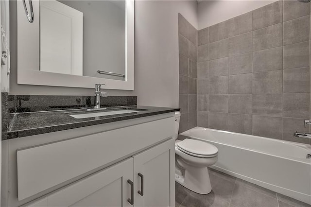 full bathroom featuring tiled shower / bath, vanity, toilet, and tile patterned flooring