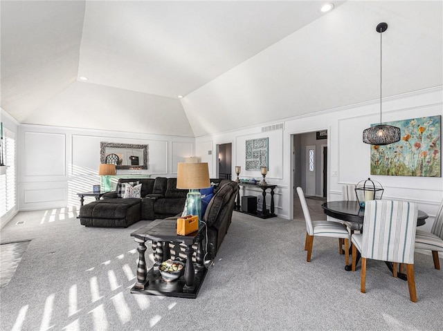 living room with light carpet, vaulted ceiling, visible vents, and a decorative wall