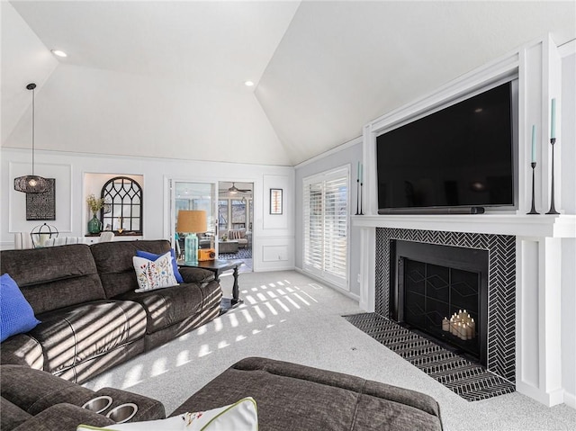 living room featuring carpet floors, high vaulted ceiling, a fireplace with flush hearth, and a decorative wall