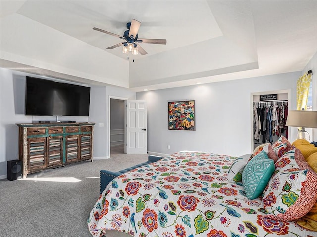 bedroom with carpet flooring, baseboards, a spacious closet, a closet, and a tray ceiling