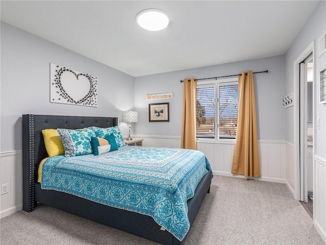 bedroom with a wainscoted wall and carpet