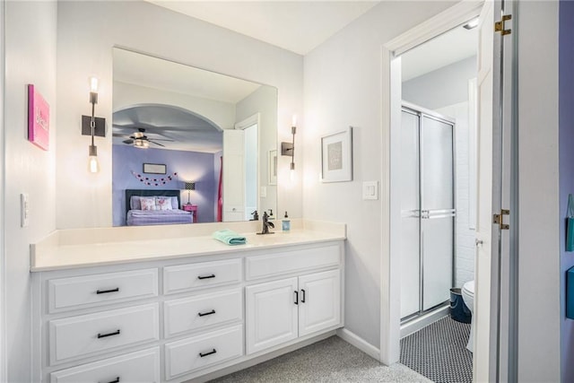 bathroom featuring baseboards, a ceiling fan, ensuite bath, vanity, and a shower stall