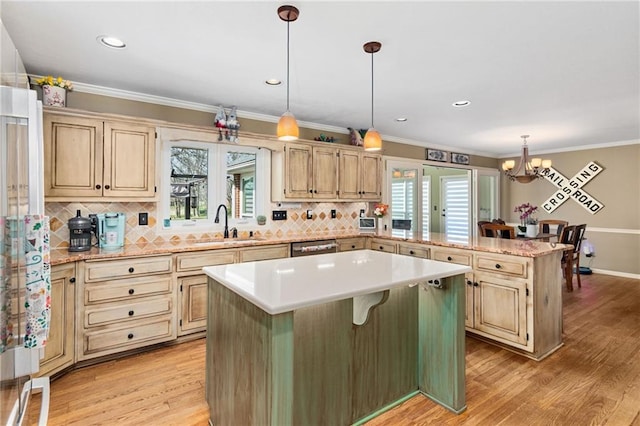 kitchen with a peninsula, a kitchen breakfast bar, light countertops, a center island, and light wood finished floors