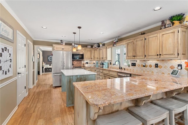 kitchen featuring stainless steel appliances, a peninsula, a breakfast bar, a kitchen island, and ornamental molding