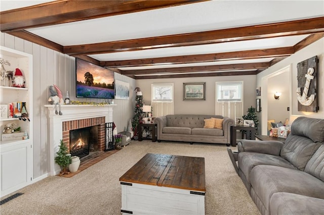 carpeted living room featuring a brick fireplace and beamed ceiling