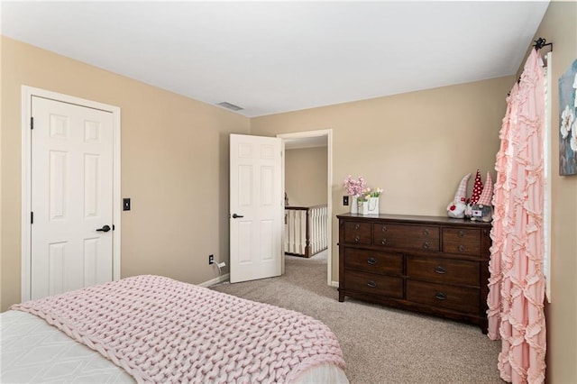 bedroom with light carpet, visible vents, and baseboards