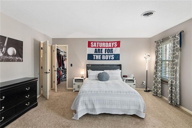 carpeted bedroom with a walk in closet and a closet