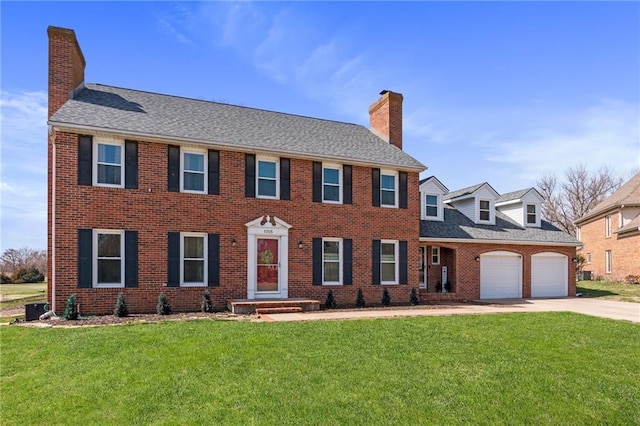 colonial-style house with concrete driveway, brick siding, a chimney, and a front lawn