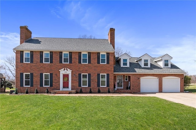 colonial-style house featuring a garage, concrete driveway, a chimney, and a front lawn