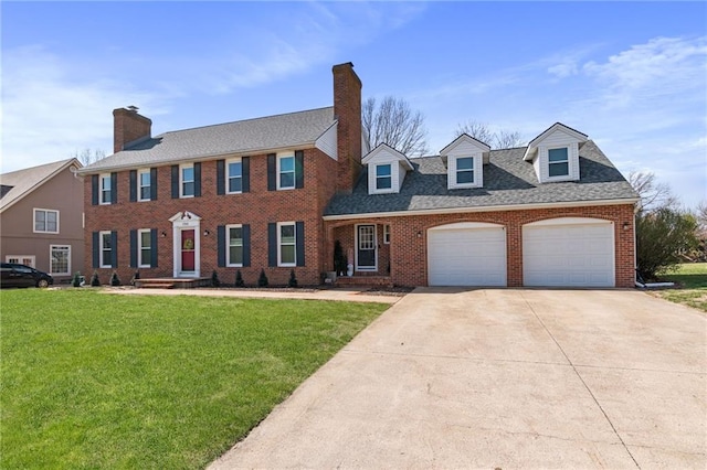 colonial house with an attached garage, driveway, brick siding, and a front yard