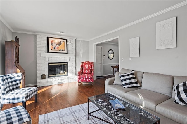 living room with a brick fireplace, ornamental molding, and dark hardwood / wood-style floors