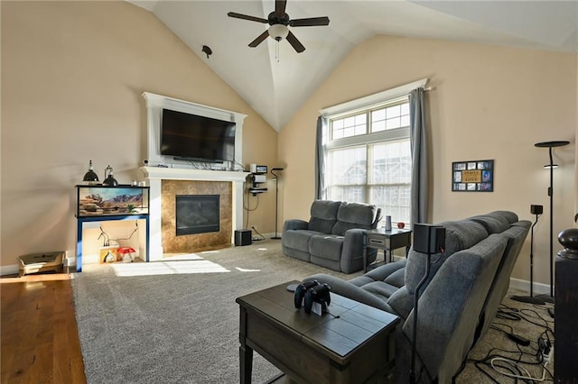 living room with a tiled fireplace, lofted ceiling, and ceiling fan