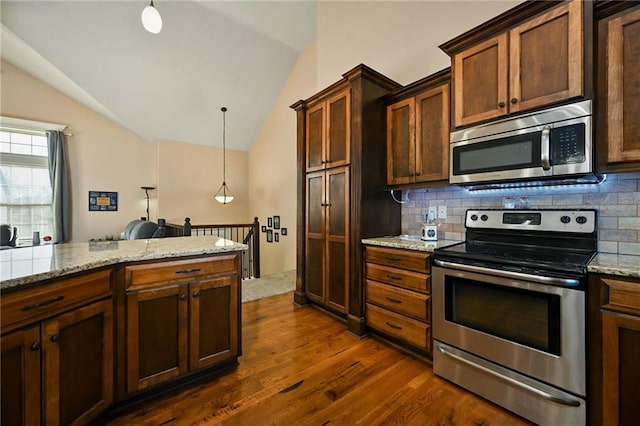 kitchen featuring tasteful backsplash, dark wood-style flooring, stainless steel appliances, and vaulted ceiling