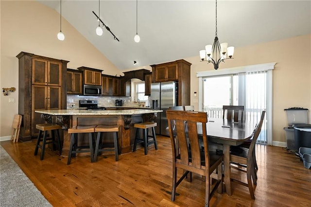 dining area with dark wood-style floors, high vaulted ceiling, and baseboards