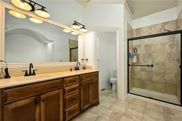 full bath featuring a sink, toilet, double vanity, and a shower stall