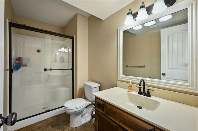 bathroom with a shower stall, toilet, and vanity