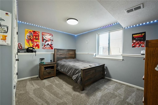 bedroom with visible vents, carpet flooring, a textured ceiling, and baseboards