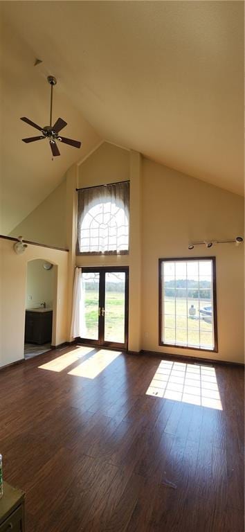 unfurnished living room featuring dark hardwood / wood-style floors, high vaulted ceiling, french doors, and ceiling fan