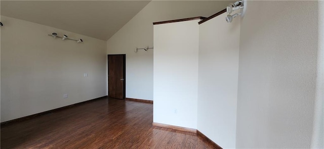 unfurnished room with dark hardwood / wood-style floors and vaulted ceiling