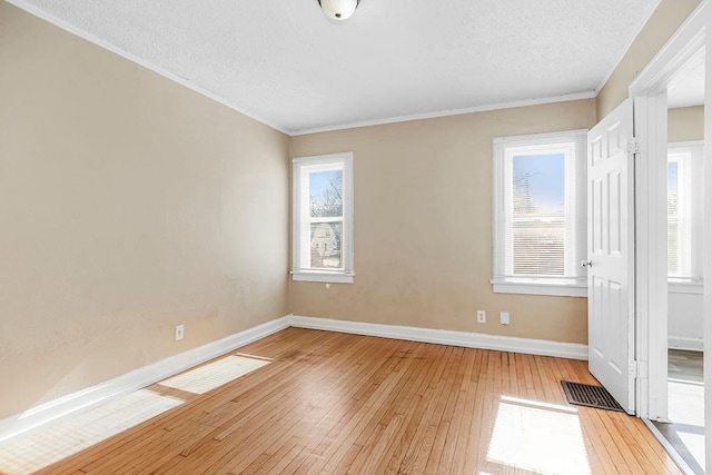 unfurnished bedroom with multiple windows, a textured ceiling, and light hardwood / wood-style flooring