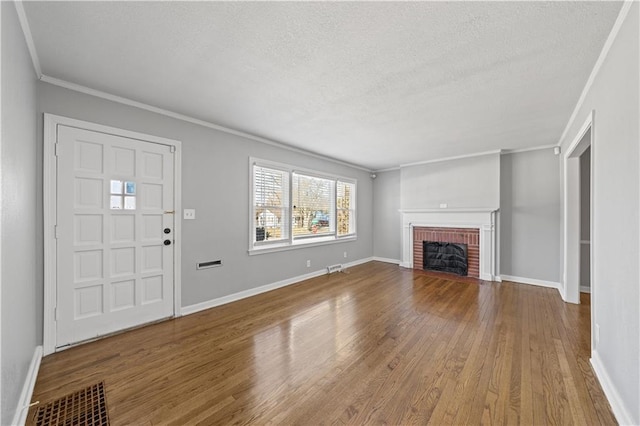 unfurnished living room with crown molding, a fireplace, hardwood / wood-style floors, and a textured ceiling