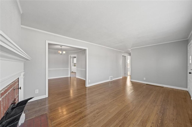 unfurnished living room with crown molding, dark hardwood / wood-style floors, and a chandelier