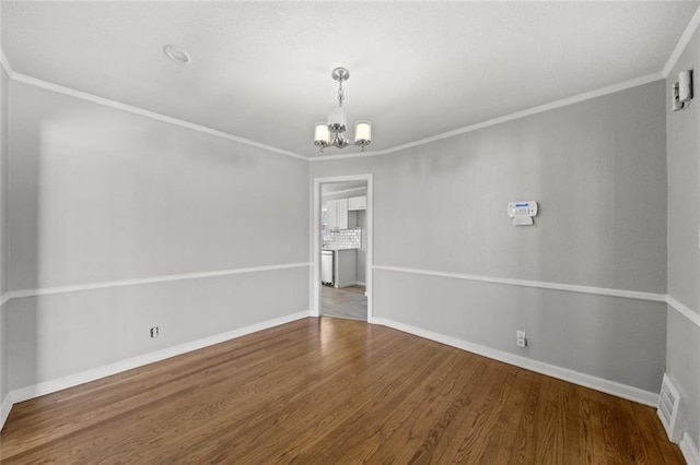 unfurnished room with an inviting chandelier, hardwood / wood-style flooring, and crown molding