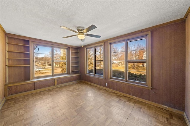 unfurnished sunroom with ceiling fan