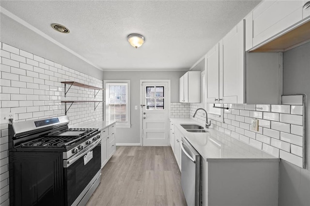 kitchen featuring white cabinetry, appliances with stainless steel finishes, sink, and light hardwood / wood-style flooring