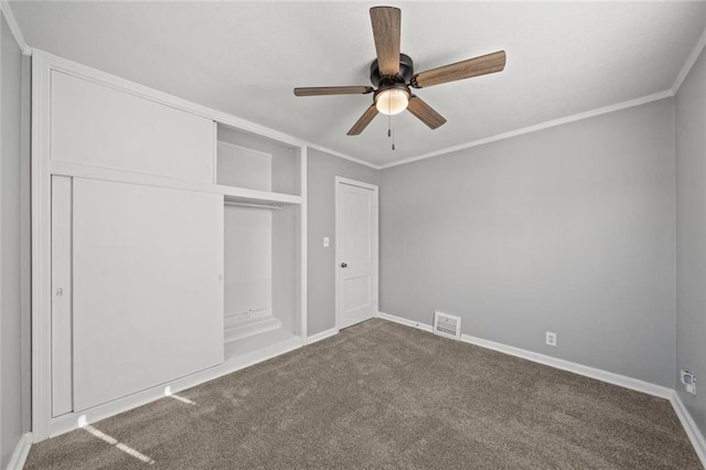 unfurnished bedroom featuring ornamental molding, carpet, ceiling fan, and a closet