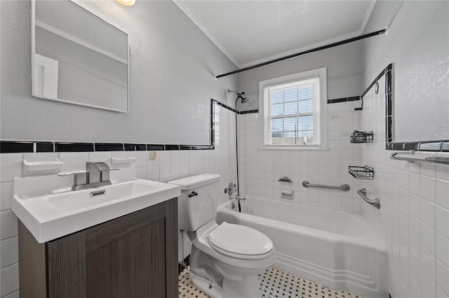 full bathroom with tile walls, vanity, ornamental molding, toilet, and tiled shower / bath